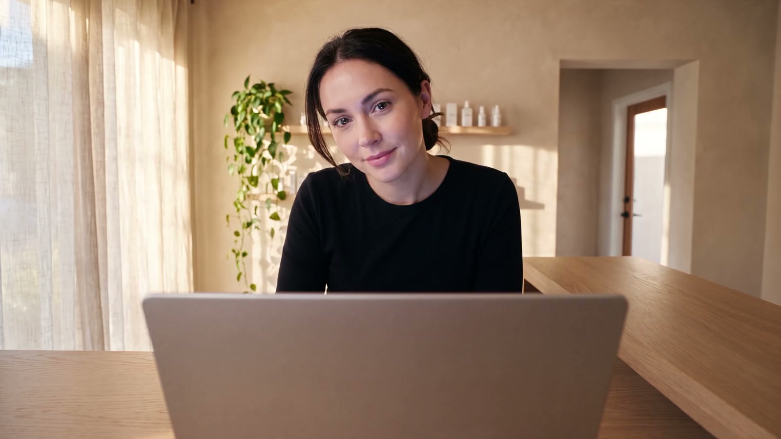 Une praticienne à son comptoir, vue depuis l'écran de son ordinateur, et devant elle les notifications de son site Kalmy